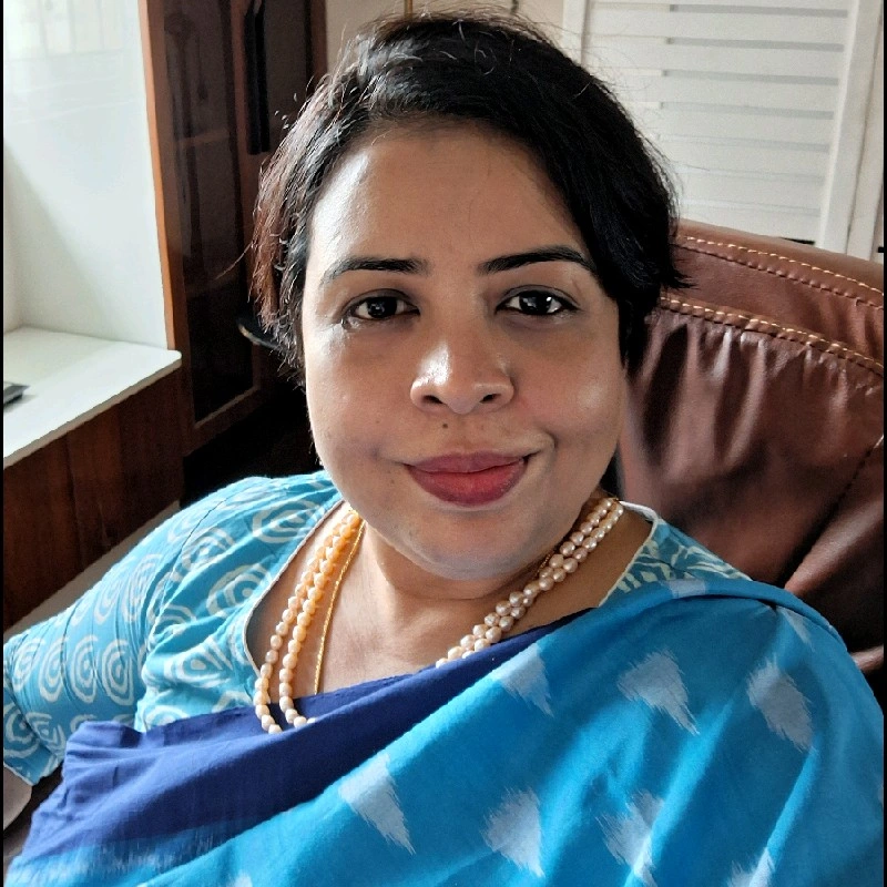 Professional portrait of Dr. Nupur Mukherjee in white lab coat with confident smile in modern laboratory setting